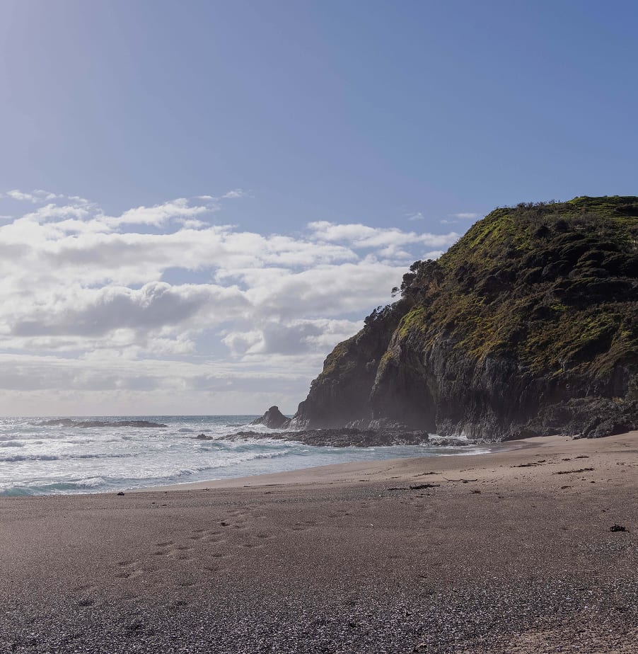 Ground-level private beach — wave-washed sand and headland