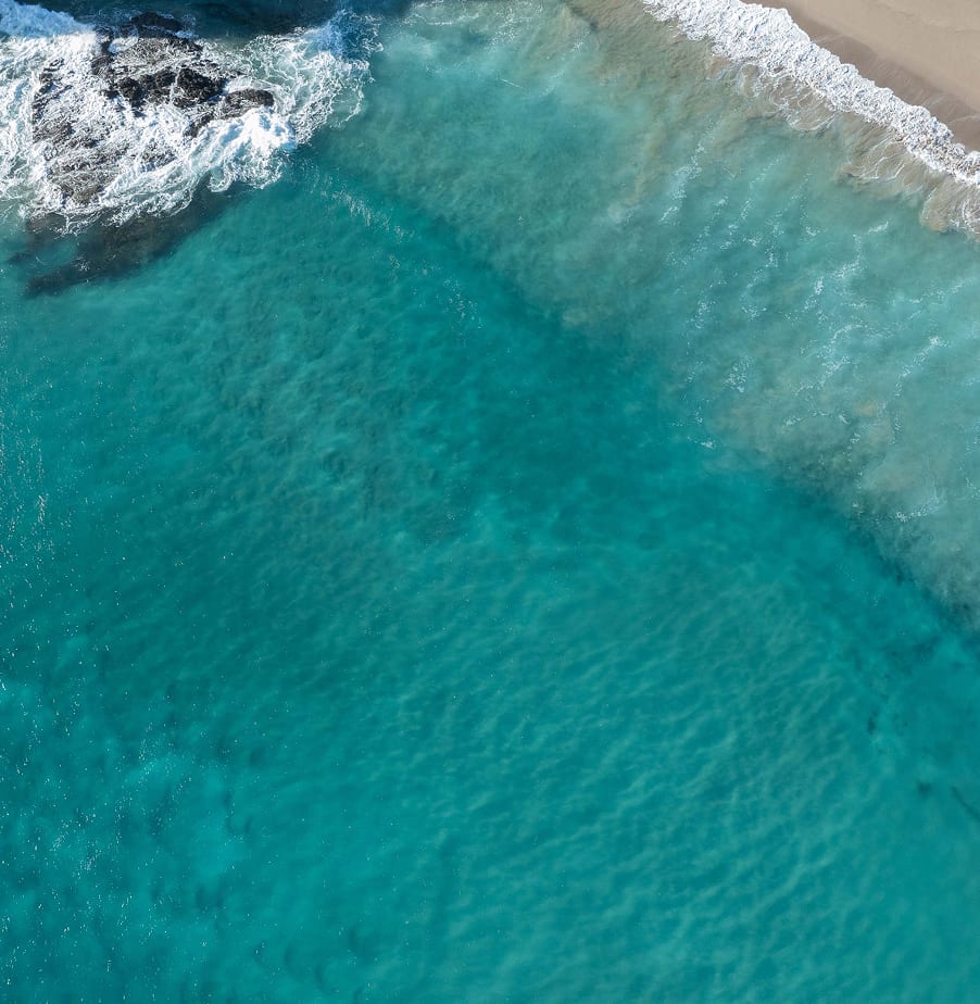 Aerial view of turquoise water and rocks at a Mataka Station beach