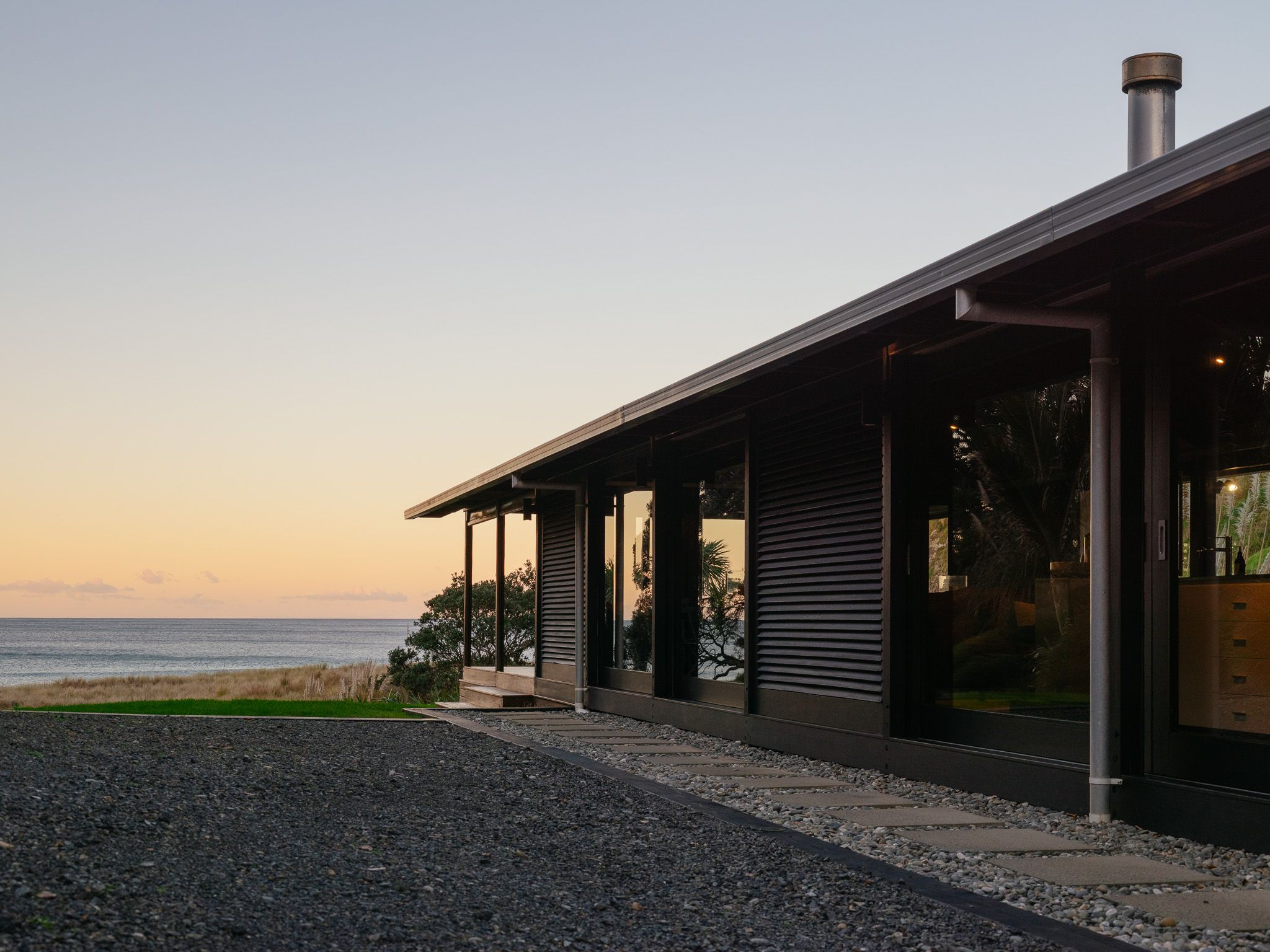 The lodge at dusk, its veranda open to the water beyond